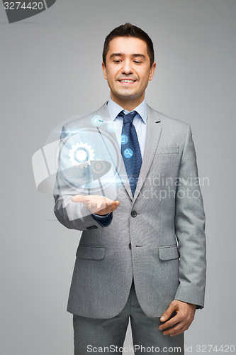 Image of happy businessman showing virtual projection