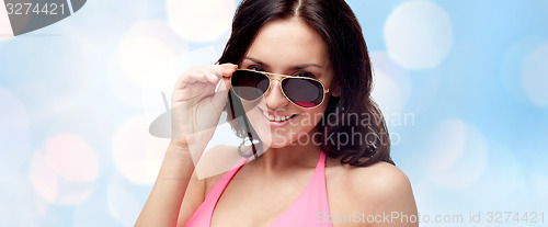 Image of happy woman in sunglasses and swimsuit