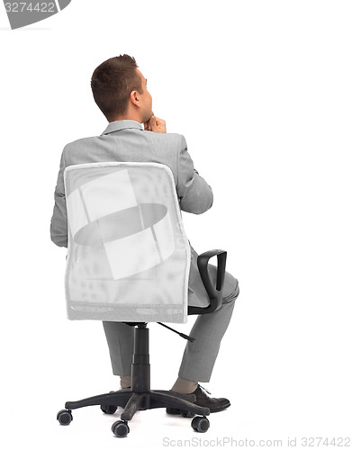 Image of businessman sitting in office chair from back