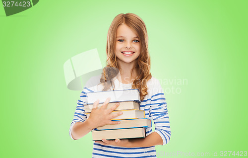 Image of happy little student girl with many books