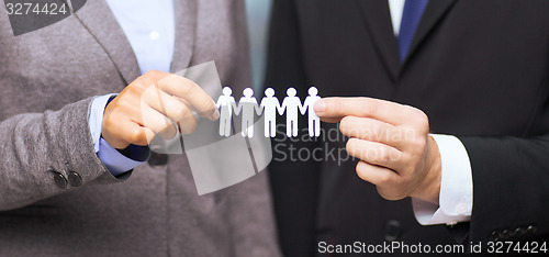 Image of businessman and businesswoman holding paper team