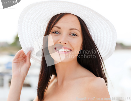 Image of girl in hat standing on the beach