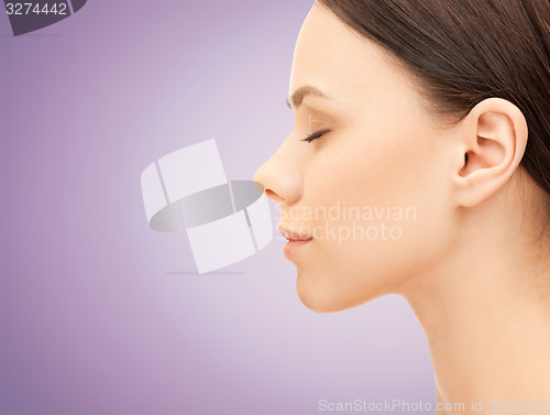 Image of beautiful young woman face over violet background