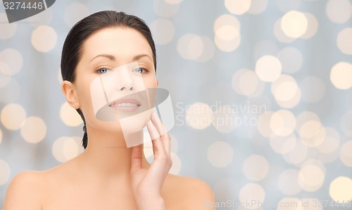 Image of beautiful young woman touching her face