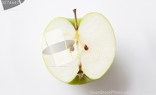 Image of ripe green apple half over white