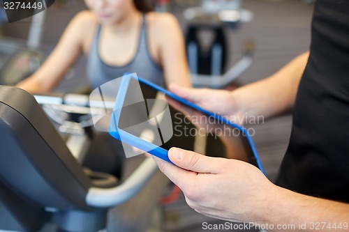 Image of close up of trainer hands with tablet pc in gym