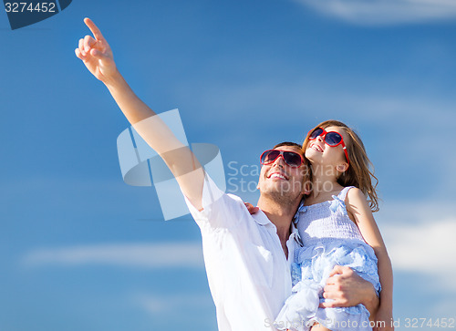 Image of happy father and child in sunglasses over blue sky