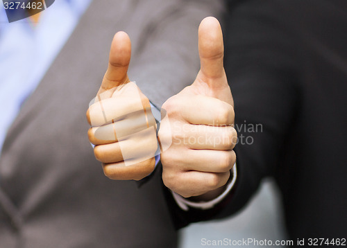 Image of businessman and businesswoman showing thumbs up