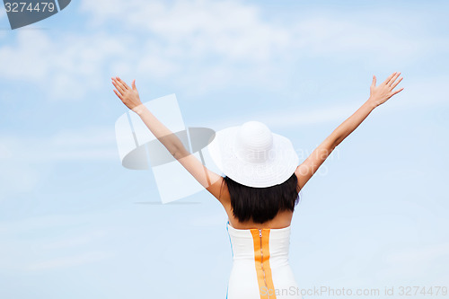 Image of girl with hands up on the beach