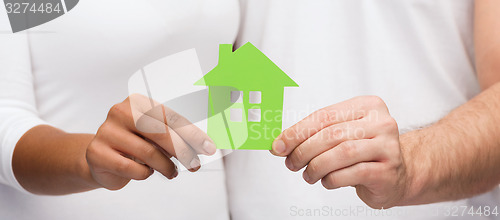 Image of couple hands holding green house