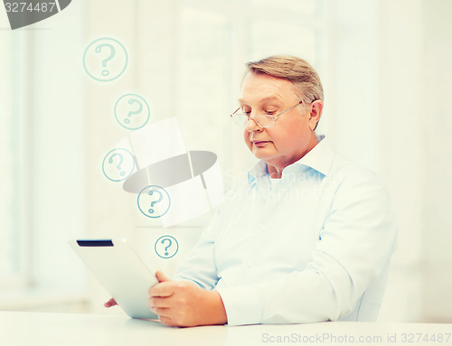 Image of old man with tablet computer at home