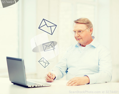 Image of old man in eyeglasses filling a form at home