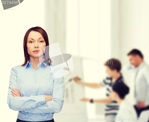 Image of smiling businesswoman with crossed arms at office