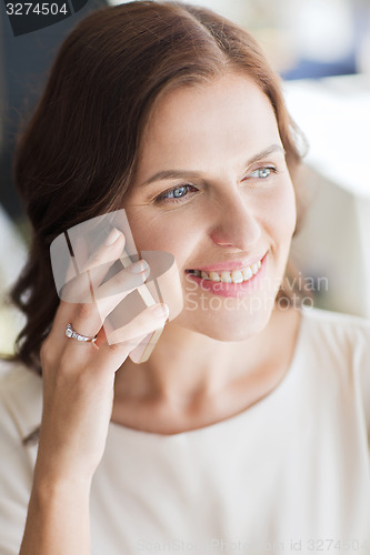 Image of happy woman calling on smart phone at restaurant