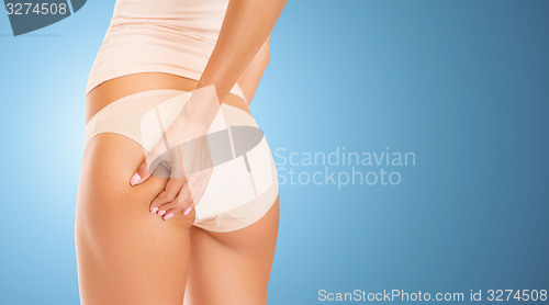 Image of close up of woman in underwear touching buttock