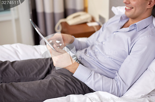 Image of businessman with tablet pc at hotel room