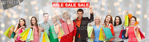 Image of happy people with red sale sign and shopping bags