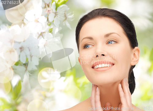 Image of beautiful young woman touching her face and neck