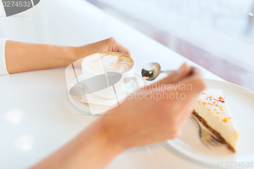 Image of close up of woman hands with cake and coffee