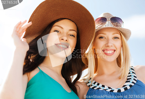 Image of girls in hats on the beach