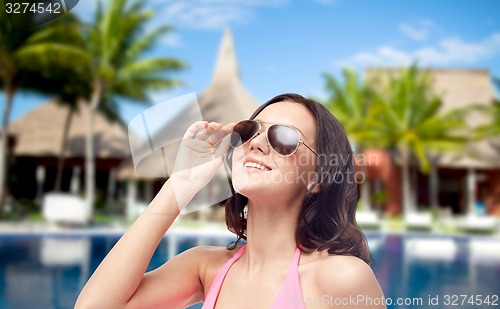 Image of happy woman in sunglasses and swimsuit on beach