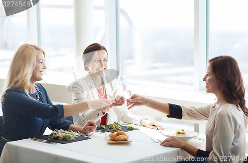 Image of happy women drinking champagne at restaurant