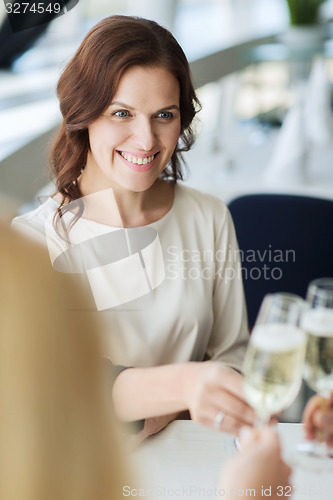 Image of happy women drinking champagne at restaurant