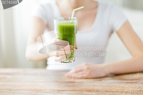 Image of close up of woman hands with green juice