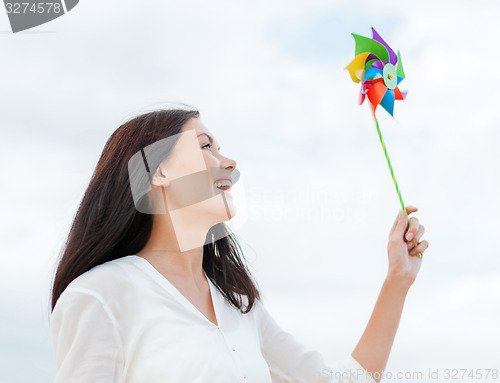 Image of girl with windmill toy on the beach