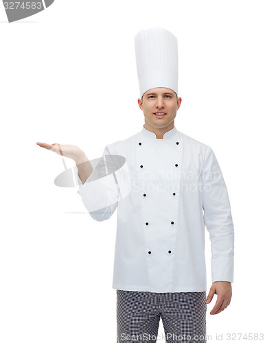 Image of happy male chef cook showing empty palm