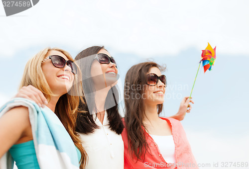 Image of smiling girls in shades having fun on the beach