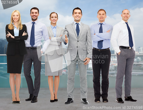 Image of group of smiling businessmen making handshake