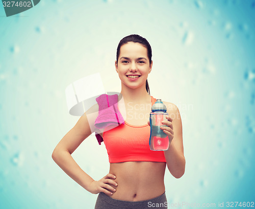Image of sporty woman with towel and water bottle