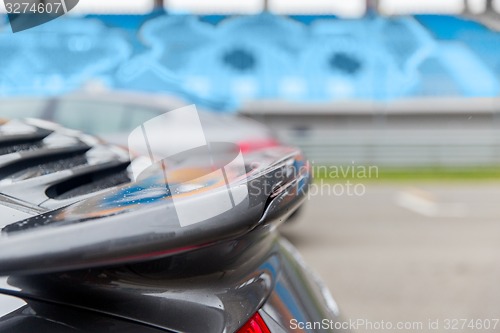 Image of close up of car spoiler on speedway at stadium