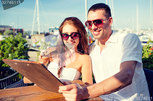 Image of smiling couple with menu at cafe