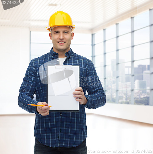 Image of smiling male builder in helmet with clipboard