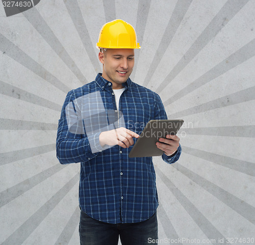 Image of smiling male builder in helmet with tablet pc