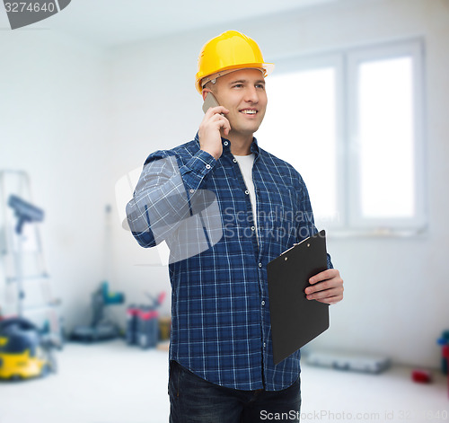 Image of smiling male builder in helmet with clipboard