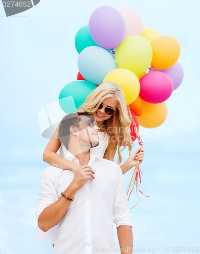 Image of couple with colorful balloons at seaside