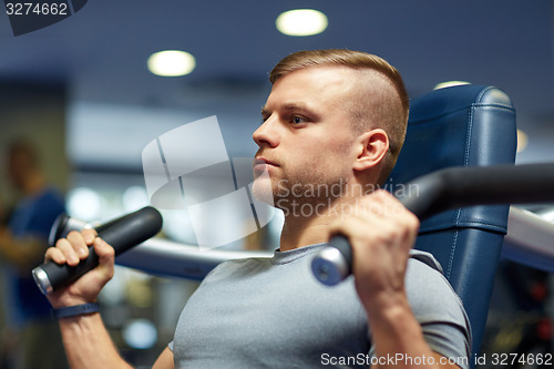 Image of man exercising and flexing muscles on gym machine