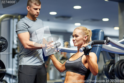 Image of man and woman flexing muscles on gym machine