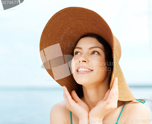 Image of girl in hat standing on the beach