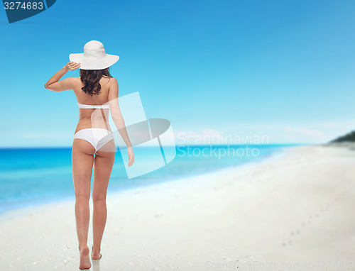 Image of young woman in white bikini swimsuit from back