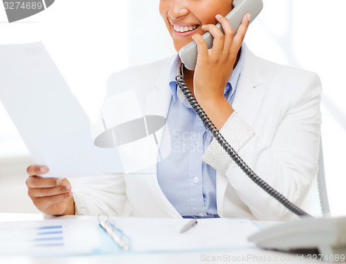 Image of african businesswoman with phone in office