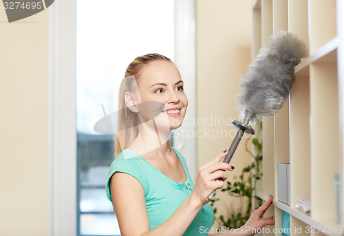 Image of happy woman with duster cleaning at home