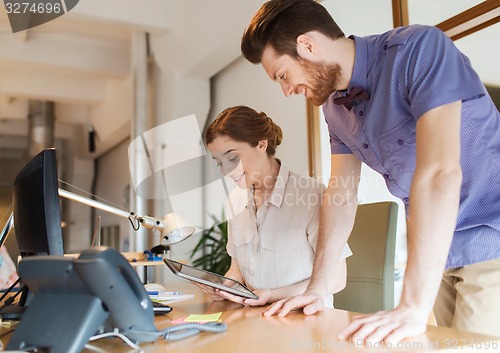 Image of happy creative team with tablet pc in office