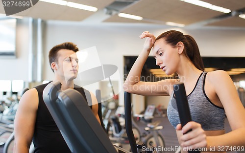 Image of woman with trainer exercising on stepper in gym