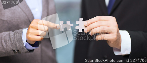 Image of businessman and businesswoman with puzzle pieces