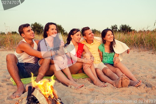 Image of smiling friends in sunglasses on summer beach