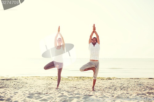 Image of couple making yoga exercises outdoors